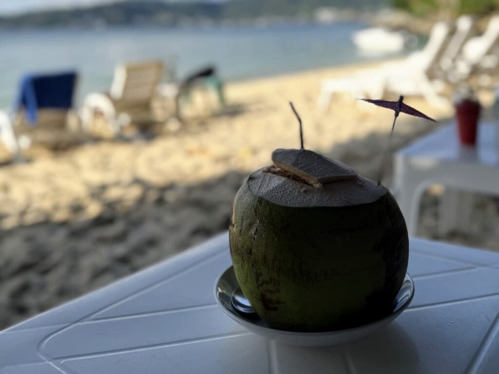 Fresh coconut served at a beachfront café on Tri Trang Beach near Patong, featured in our Patong Travel Guide.