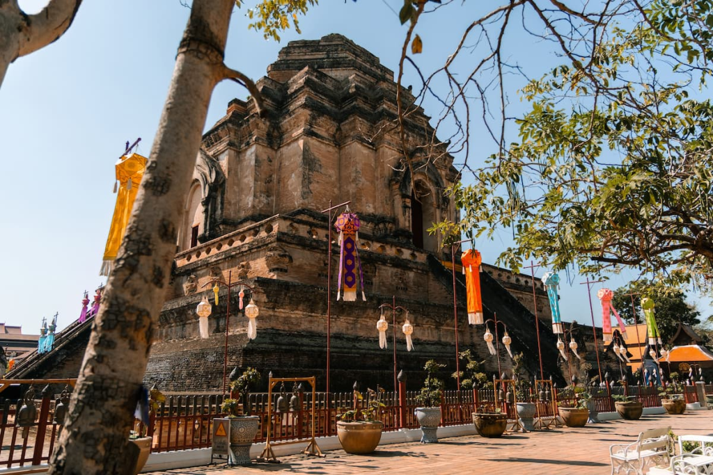 Thailand travel guide view of the ancient brick chedi at Wat Chedi Luang decorated with colourful lanterns in Chiang Mai.