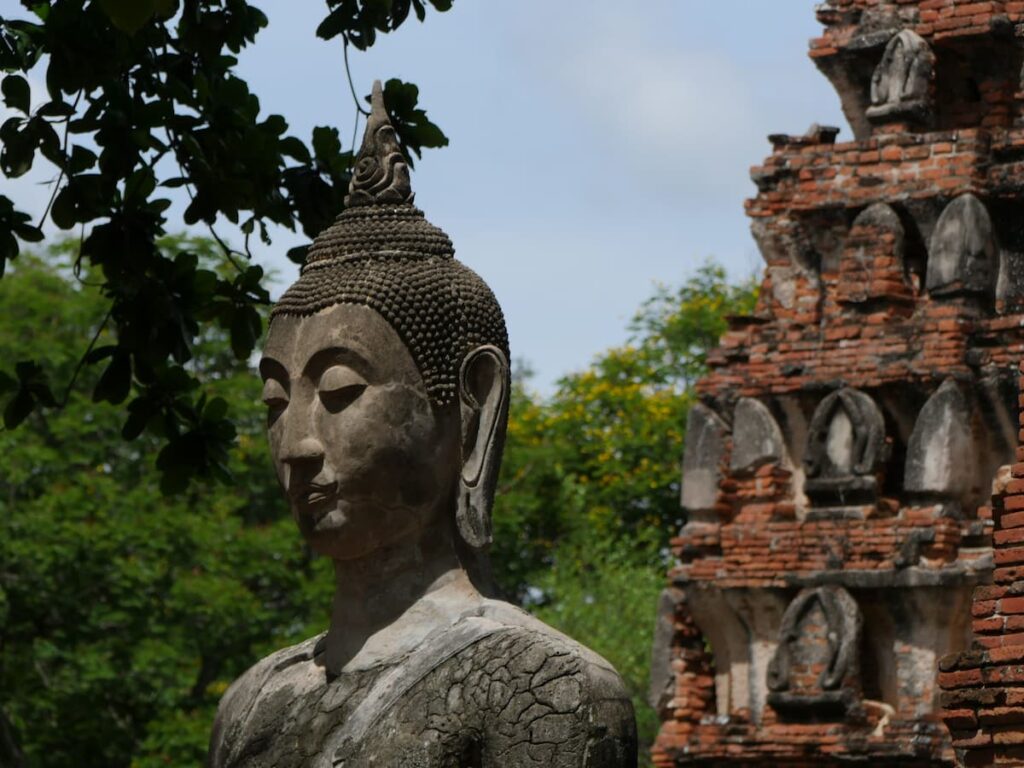 Weathered Buddha statue among the ruins of Wat Mahathat in Ayutthaya