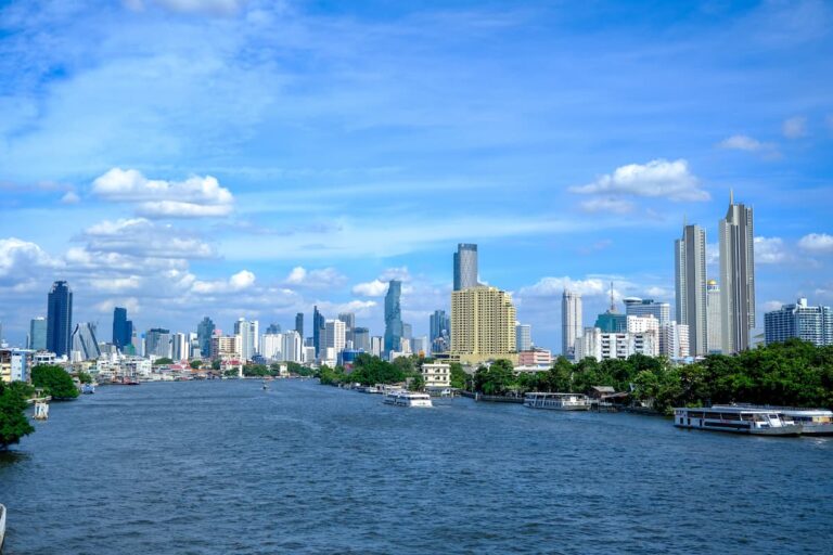 Where to go in Central Thailand, showing Bangkok’s skyline and boats travelling along the Chao Phraya River.