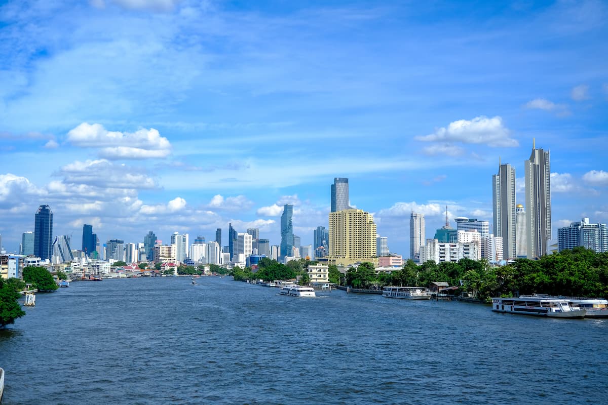 Where to go in Central Thailand, showing Bangkok’s skyline and boats travelling along the Chao Phraya River.