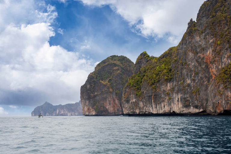 Best island day trips from Phuket featuring the limestone cliffs and open water of the Phi Phi Islands.