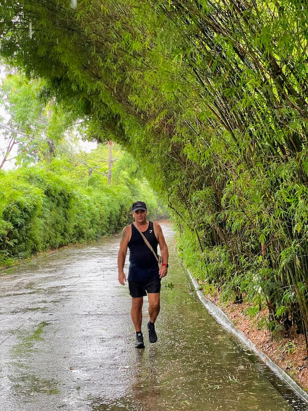 David Hibbins walking through a rain-soaked lane in Thailand