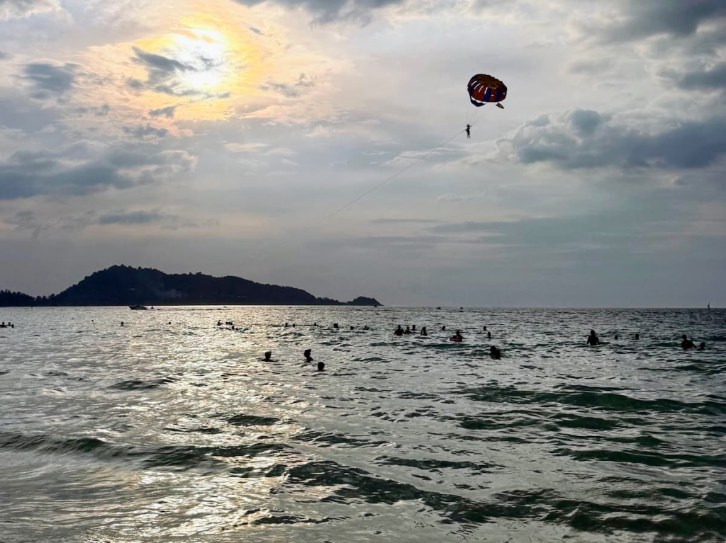 Swimming and parasailing at Patong Beach during a one day in Patong itinerary