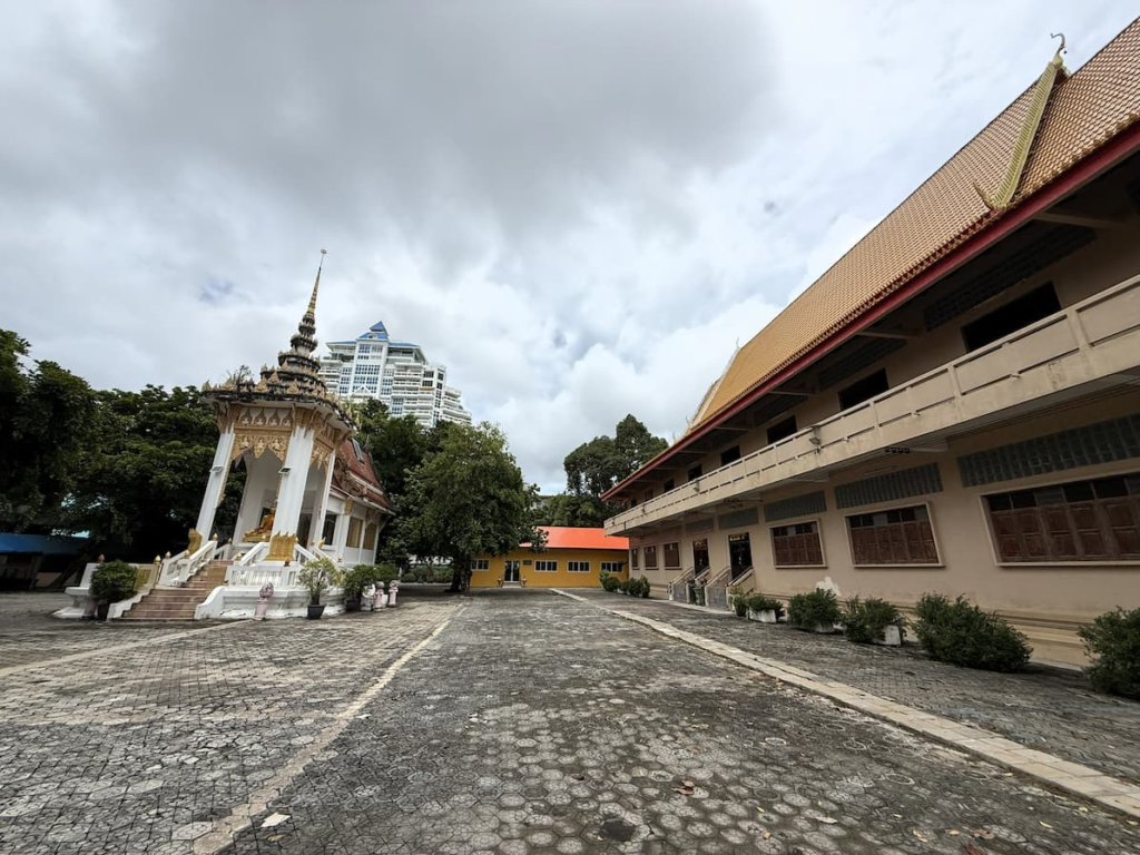Courtyard at Wat Thipphaksong Laem Phet with modern Patong buildings behind