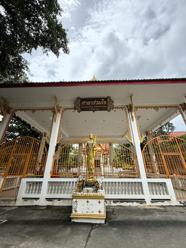 Religious hall and standing figure at Wat Thipphaksong Laem Phet